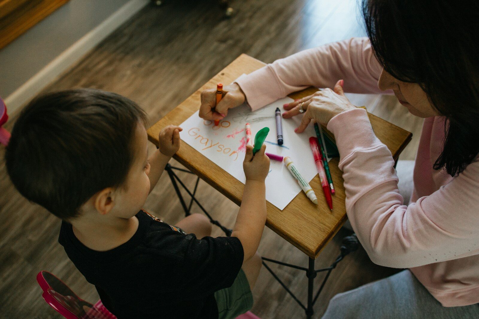 adult and child coloring at table